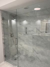 Walk-in glass shower with gray marble-look tile