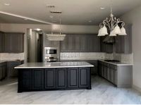 Kitchen with gray painted cabinets and a black island