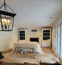Living room prepped for painting with floors and furniture covered