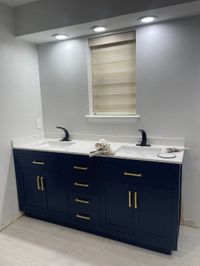 Bathroom with a navy double vanity and gold hardware
