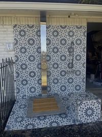 Outdoor shower remodel with patterned black and white tile