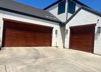 Stained wood garage doors on a modern home