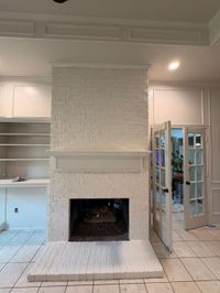 White painted brick fireplace with built-in shelves